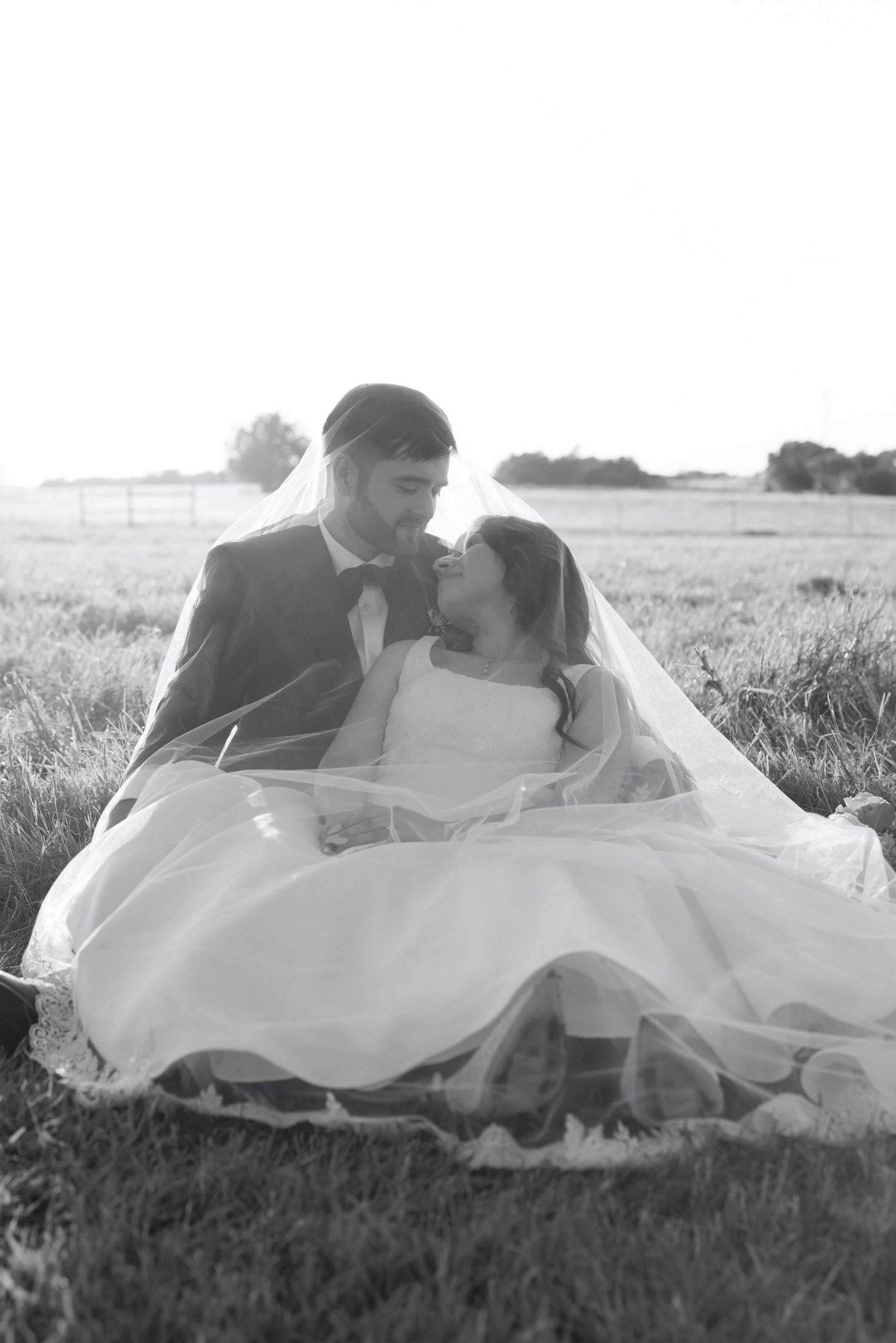 A romantic sunset photo session with newlyweds in a grassy field.