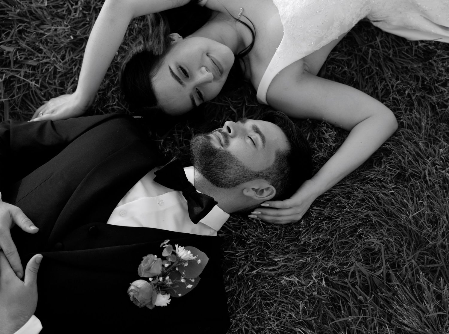A black and white portrait of newlyweds sharing an intimate moment.