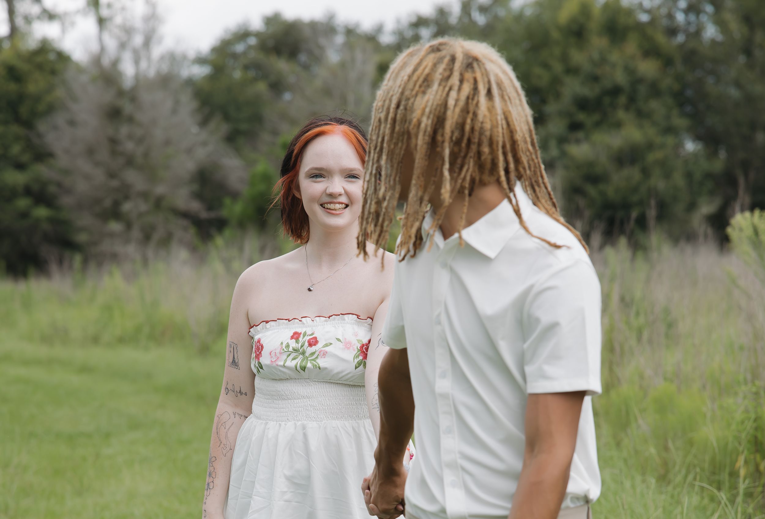 Romantic outdoor photoshoot showing couple in coordinated white and khaki outfits.
