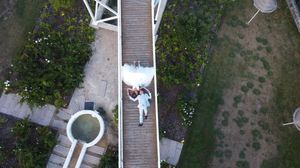 Aerial view of a wooden boardwalk with gardens and pathways surrounding it.