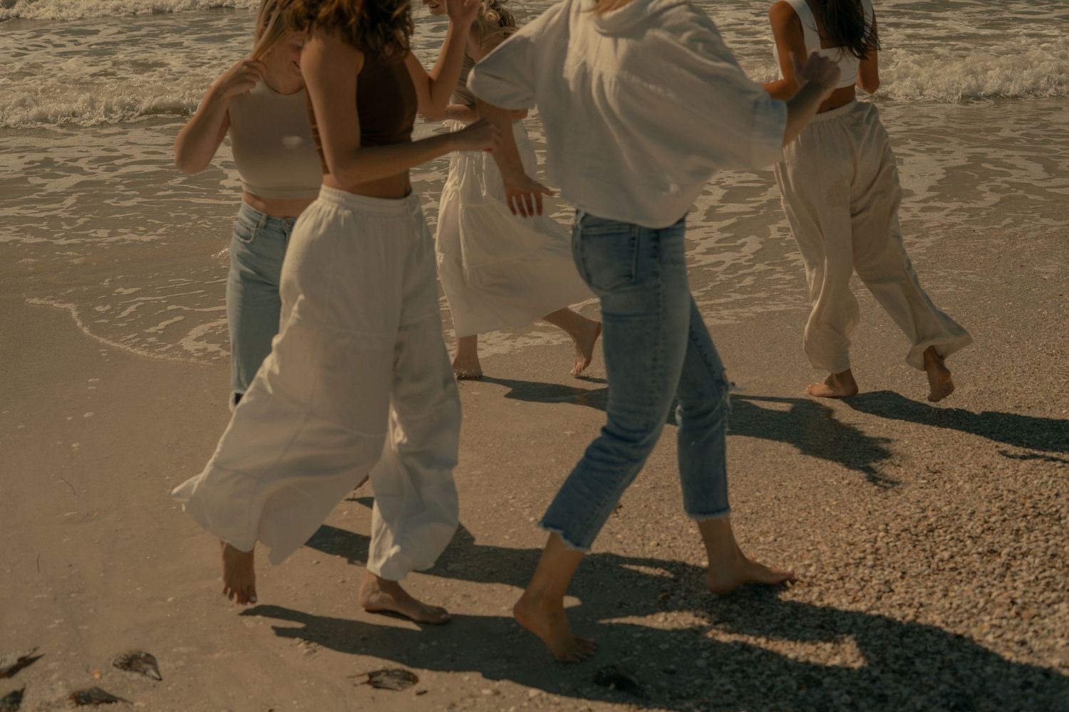5 besties running around the beach - close up of their legs running