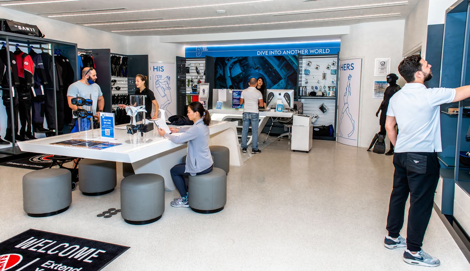 Modern retail store interior with sleek display tables, chairs, and wall-mounted merchandise showcasing a minimalist design.