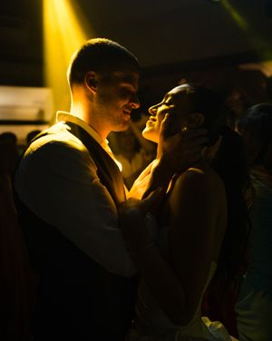 Silhouetted figures in romantic embrace captured against dramatic golden lighting creating an intimate mood.