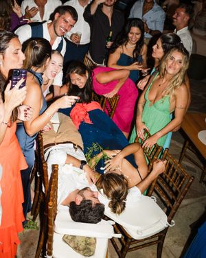 A lively wedding reception dance floor filled with guests in colorful dresses and formal attire celebrating together.