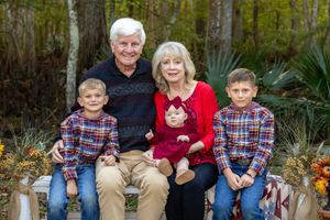Family members and their dog pose together on outdoor steps during a fall photo session.