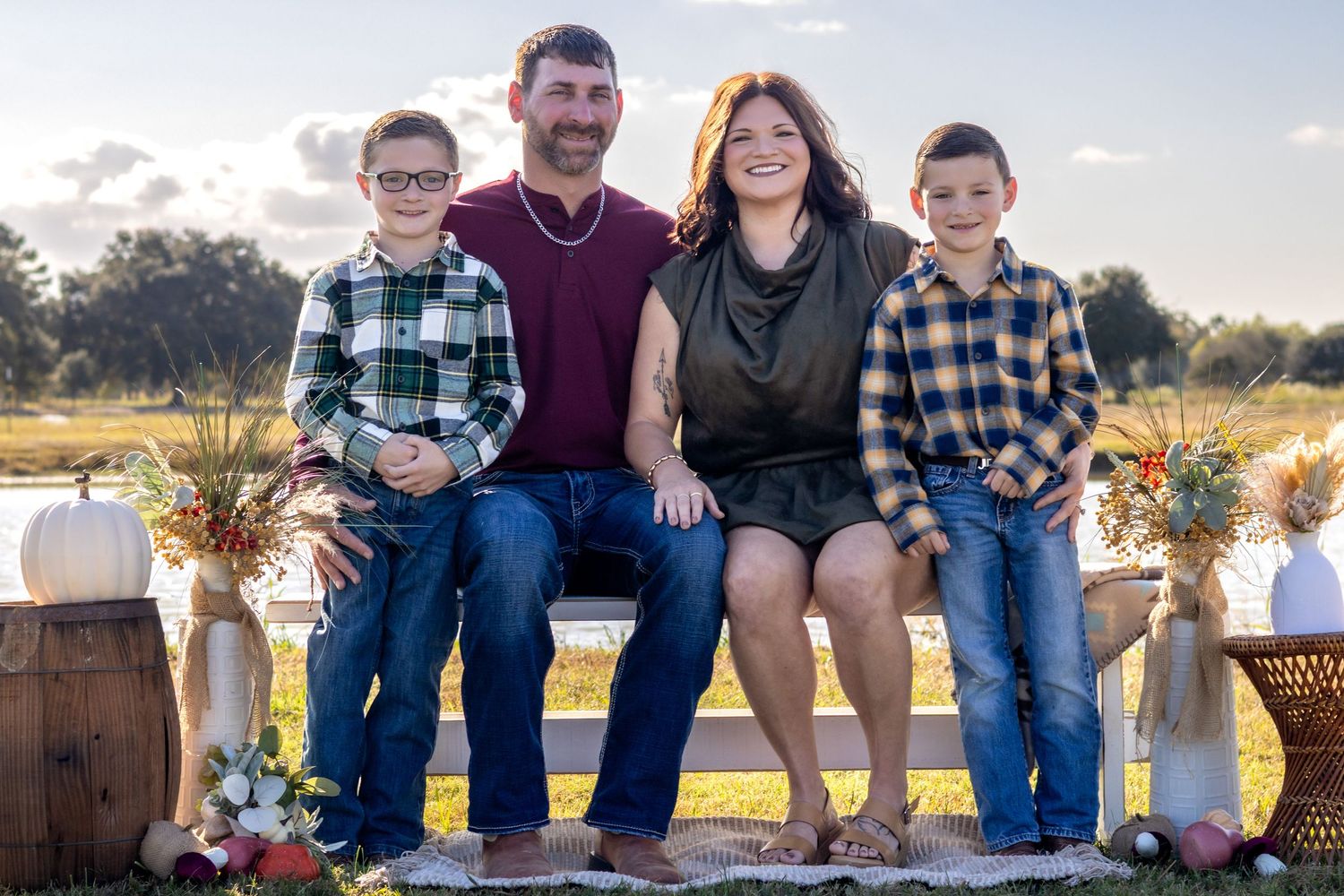 A group sits together on wooden steps outdoors during golden hour lighting for a casual portrait session.