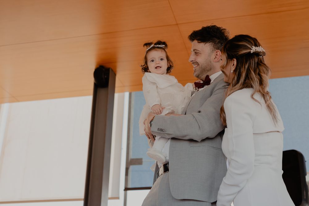 A tender family moment captured in warm lighting against a modern architectural background.