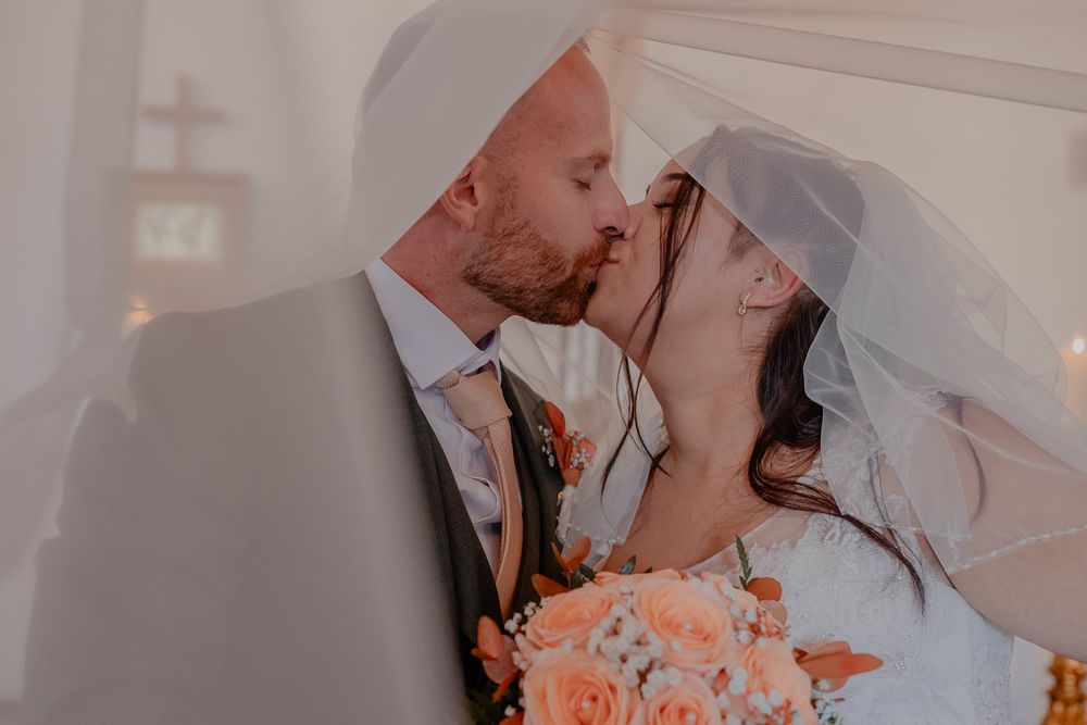 Romantic wedding couple sharing intimate moments in soft lighting.