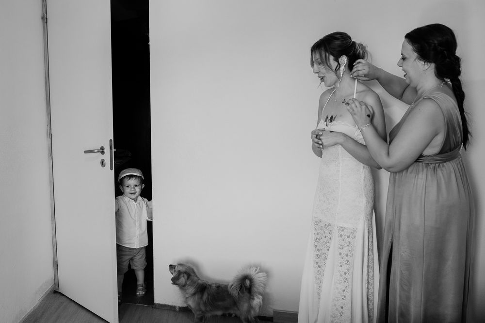 Black and white candid photo of wedding guests enjoying drinks at a celebration.