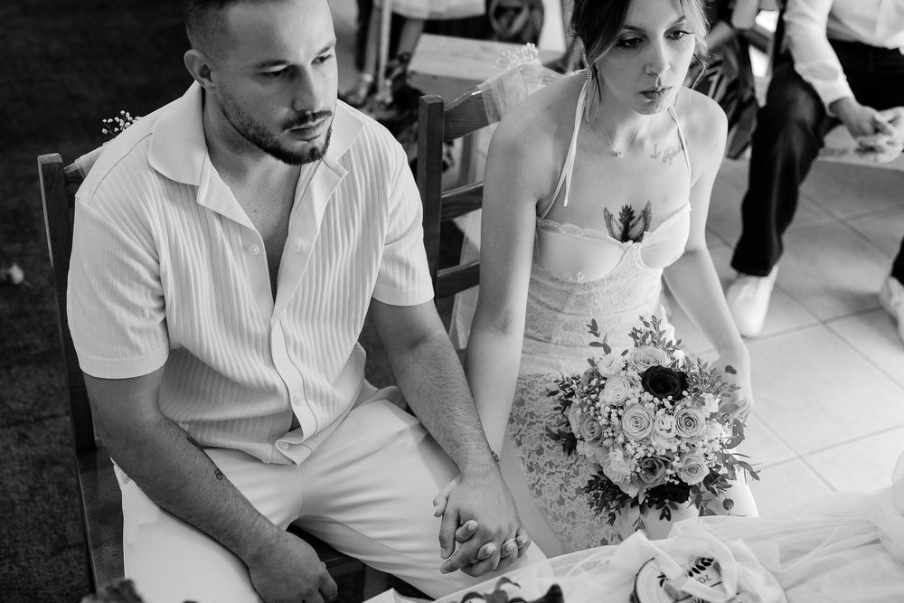 Wedding guests in white attire gathered around a table during reception celebrations.