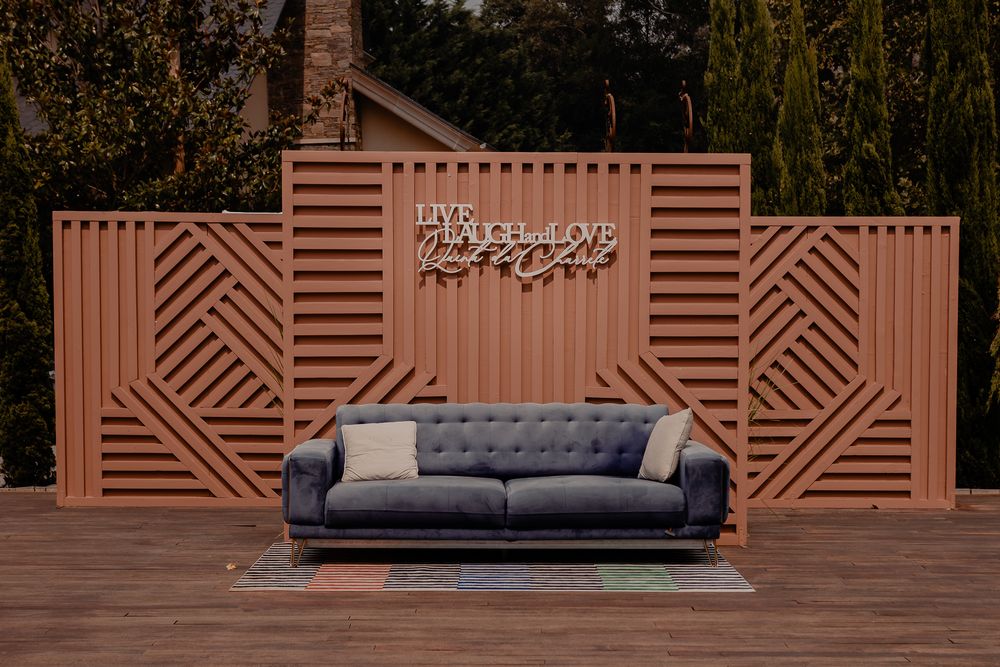 Modern geometric wooden wall panel with navy blue sofa in terracotta tones.