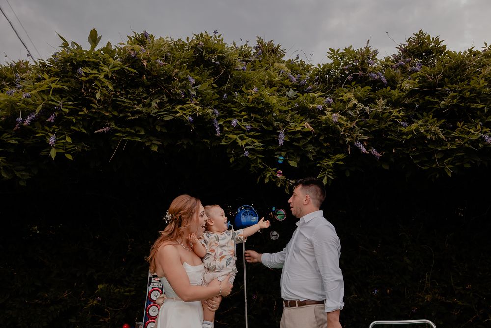 Outdoor wedding ceremony setup with white chairs and floral arrangements.