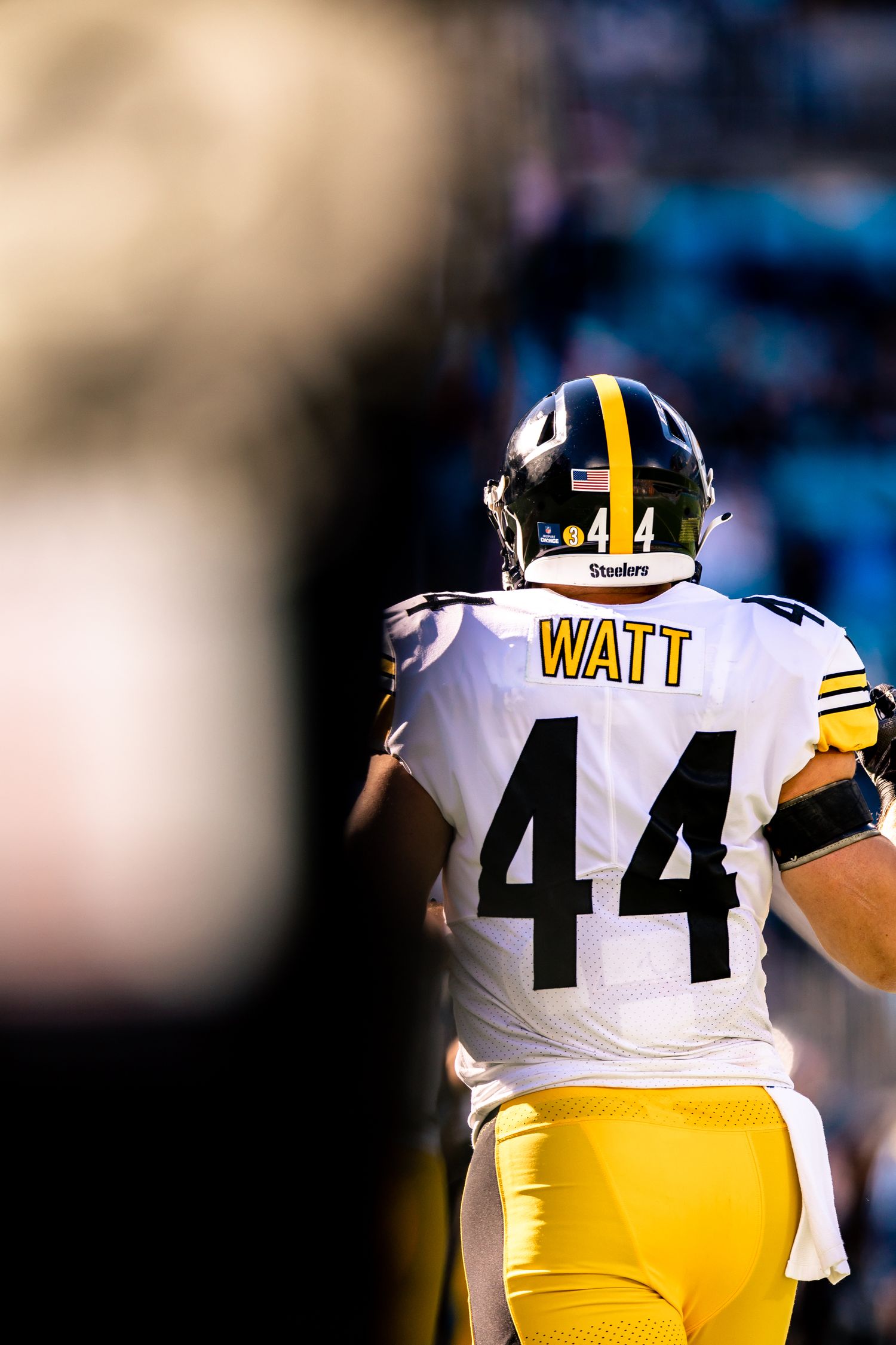 Pittsburgh Steelers player Watt number 44 stands on field in white and gold uniform.