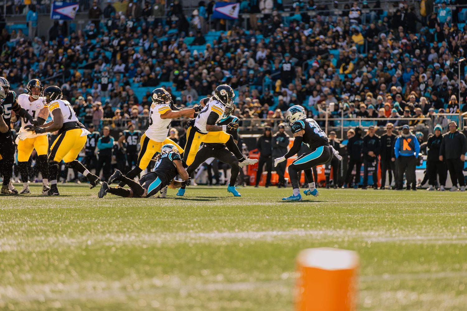 Pittsburgh Steelers players run a play against the Carolina Panthers on the field.