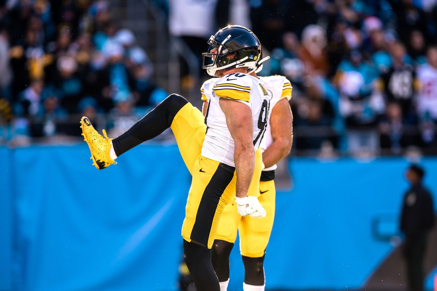 Two Pittsburgh Steelers players celebrate together on the field during an NFL game.