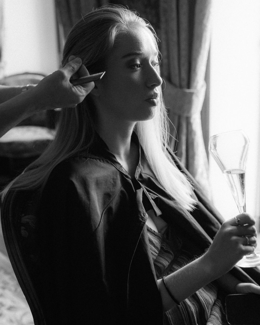 Black and white portrait showing preparation moments in natural window light.