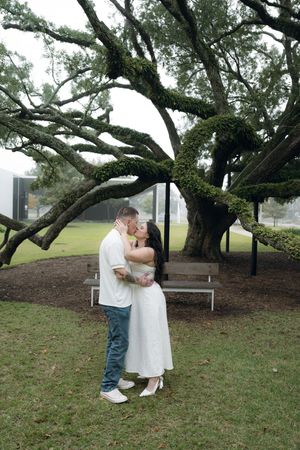 Couple sharing intimate moment under sprawling oak tree branches at the Menil Collection in Houston, Texas