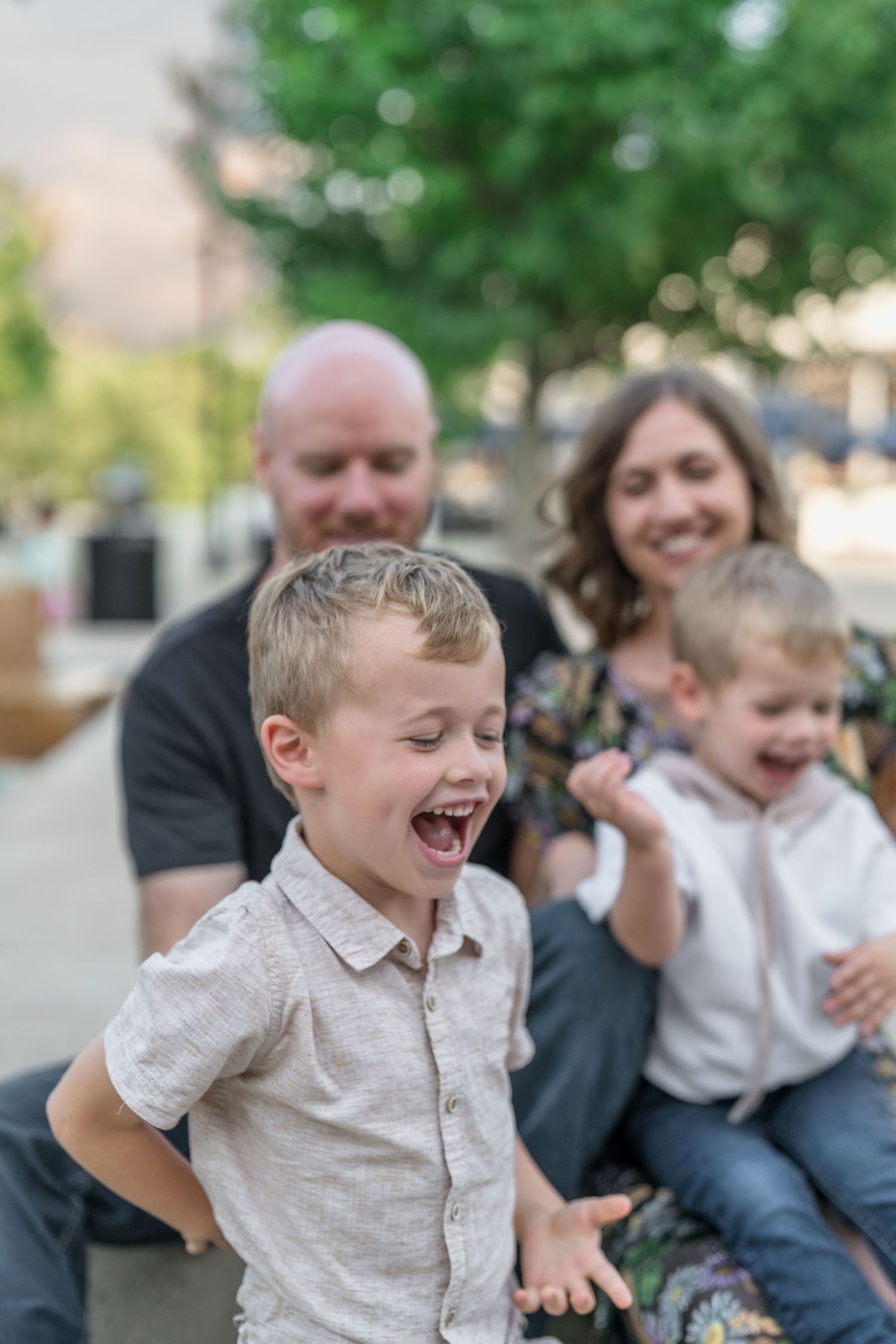A joyful family moment outdoors with genuine laughter and smiles shared for family photography session in Downtown Cuyahoga Falls, Ohio