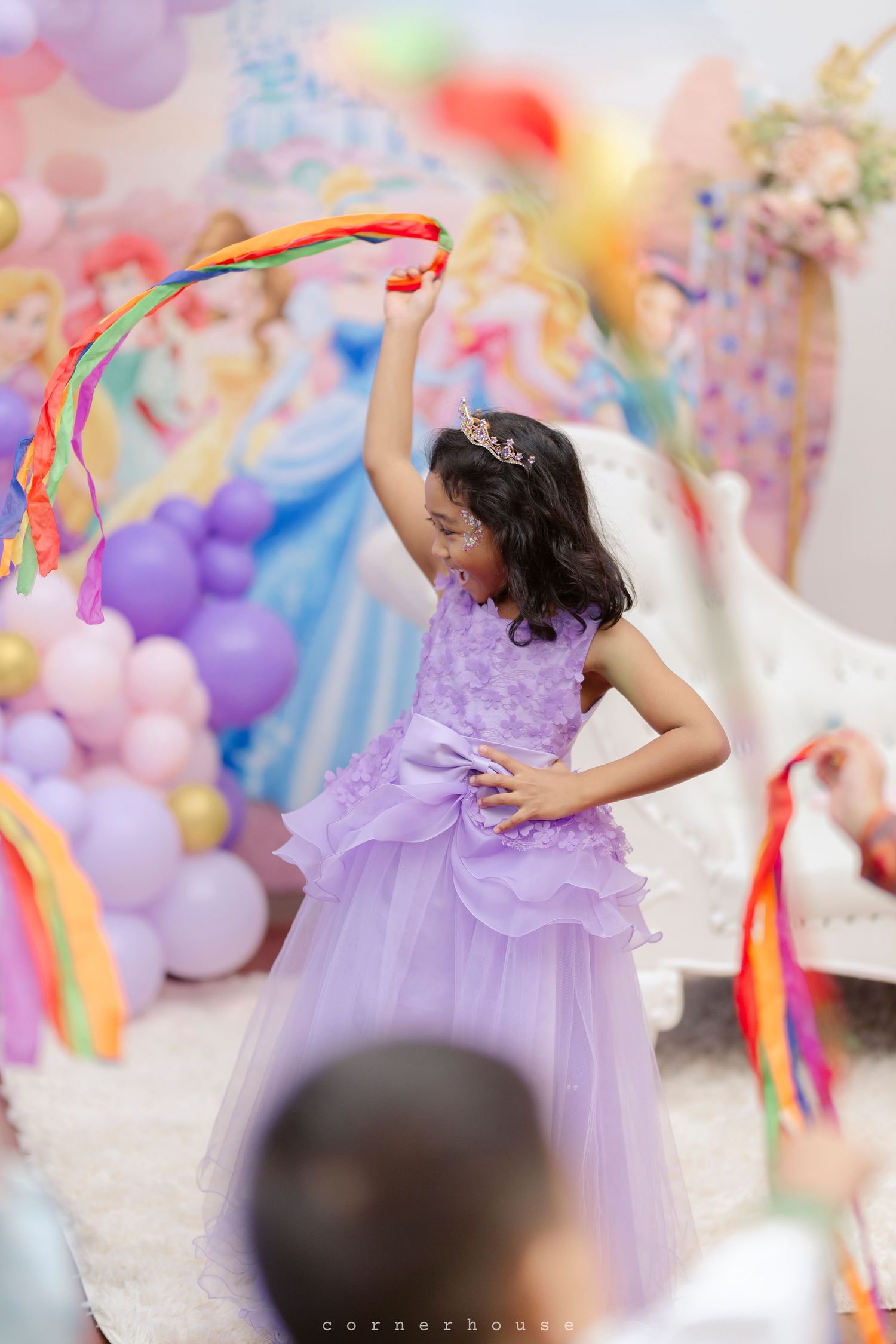 Colorful party decorations adorn a festive celebration space with pastel balloons and pink floral accents.