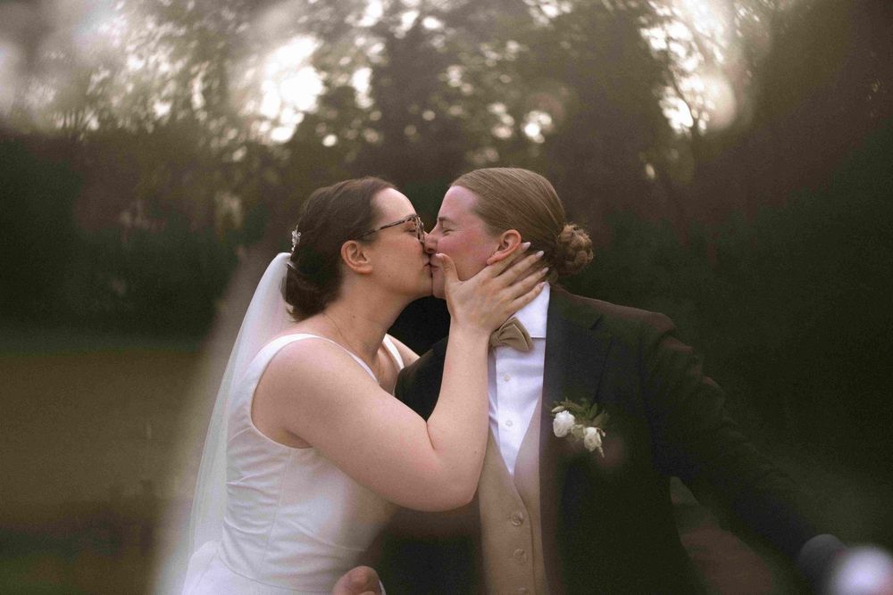 Tender wedding moment captured during sunset in a natural outdoor setting.