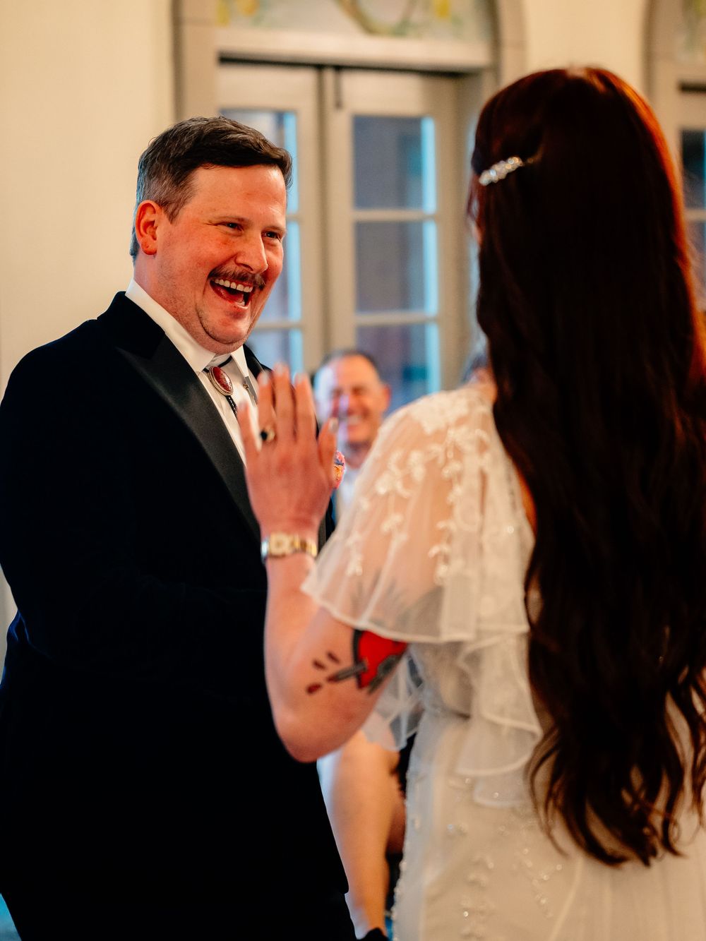Joyful wedding moment captured in a candid interaction at an indoor reception.