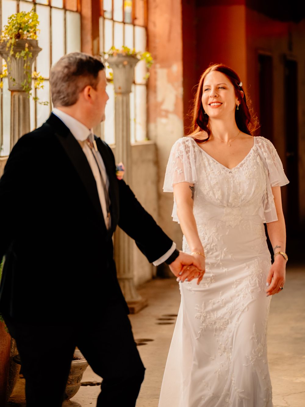 Dancing couple in formal attire twirling in an elegant venue with warm lighting.