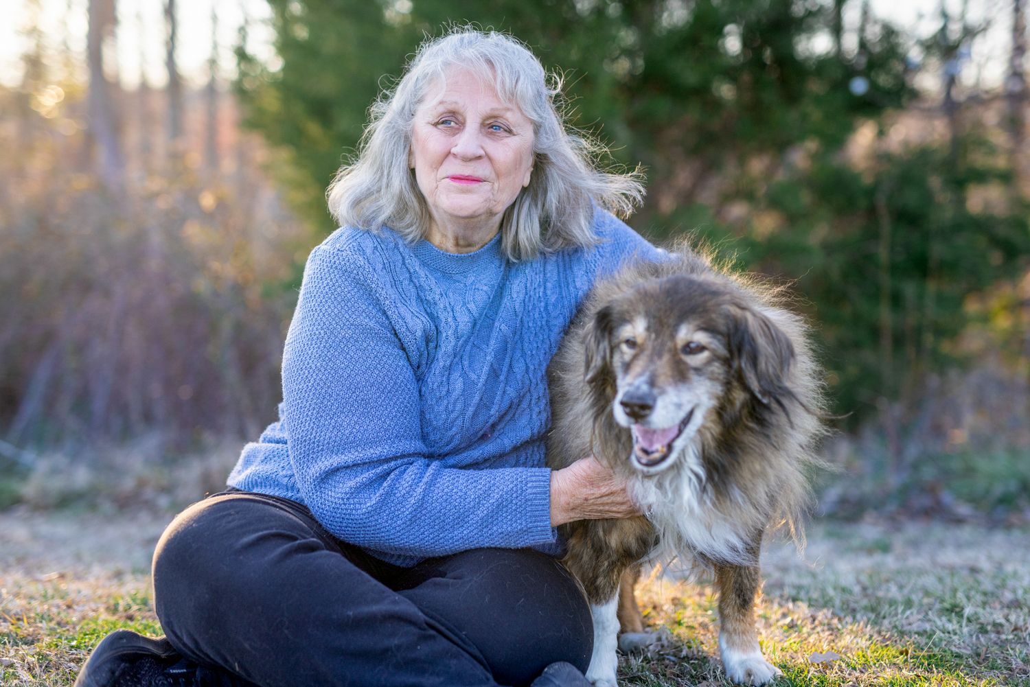 Emotional goodbye between pet and owner captured in a golden field during a meaningful end-of-life session.