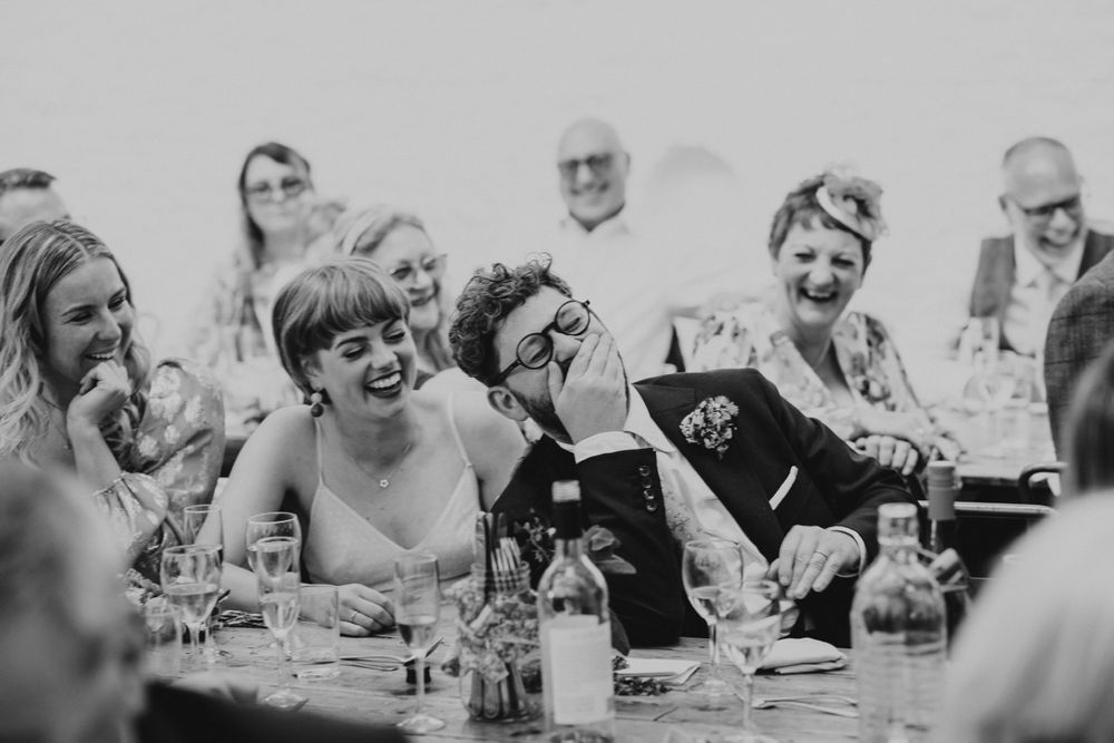 Bride and groom reaction during the wedding speeches at Silk Mill barn in frome