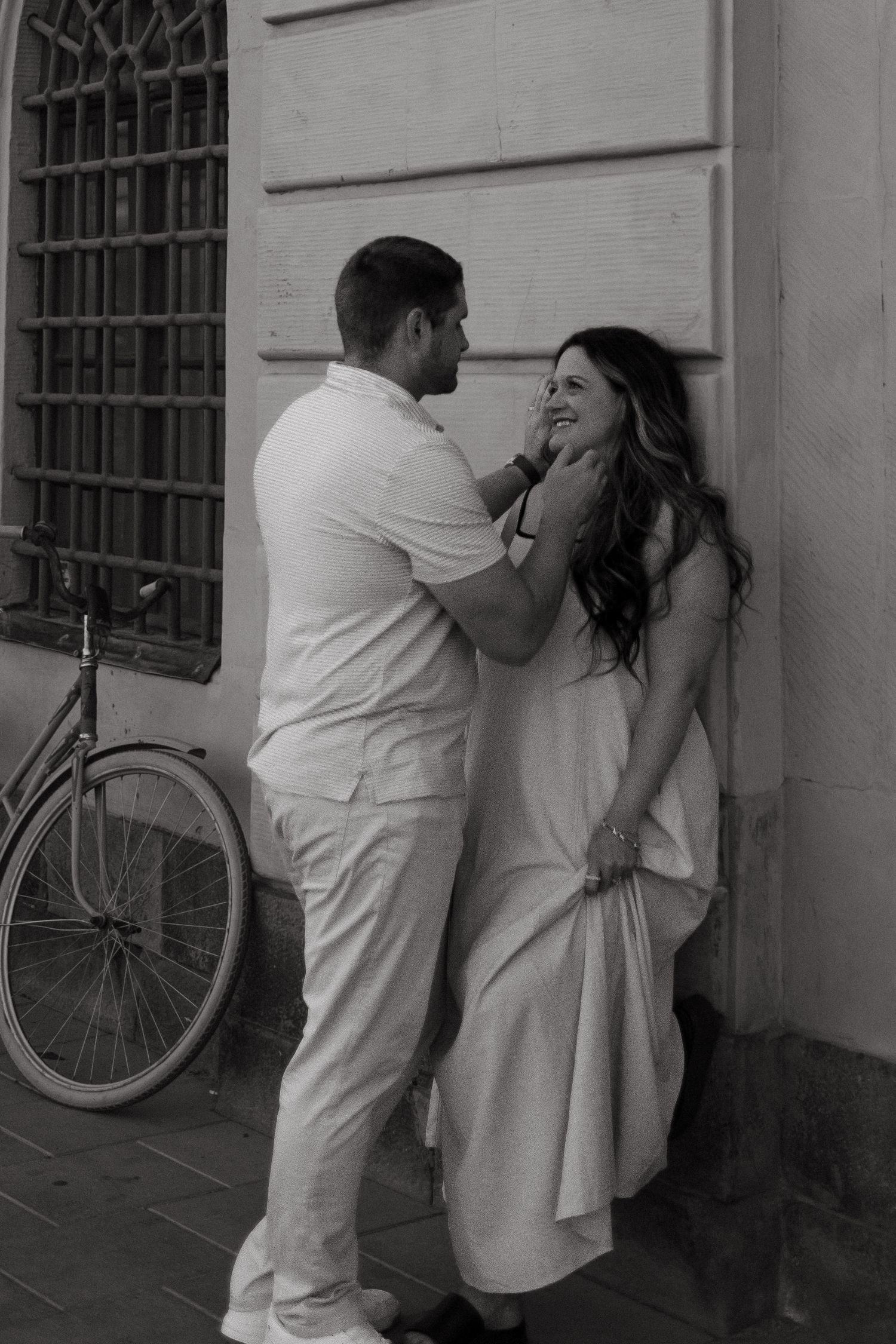 man stroking his wife's cheek as they share a quiet moment in Stockholm streets during documentary vacation photoshoot in Stockholm