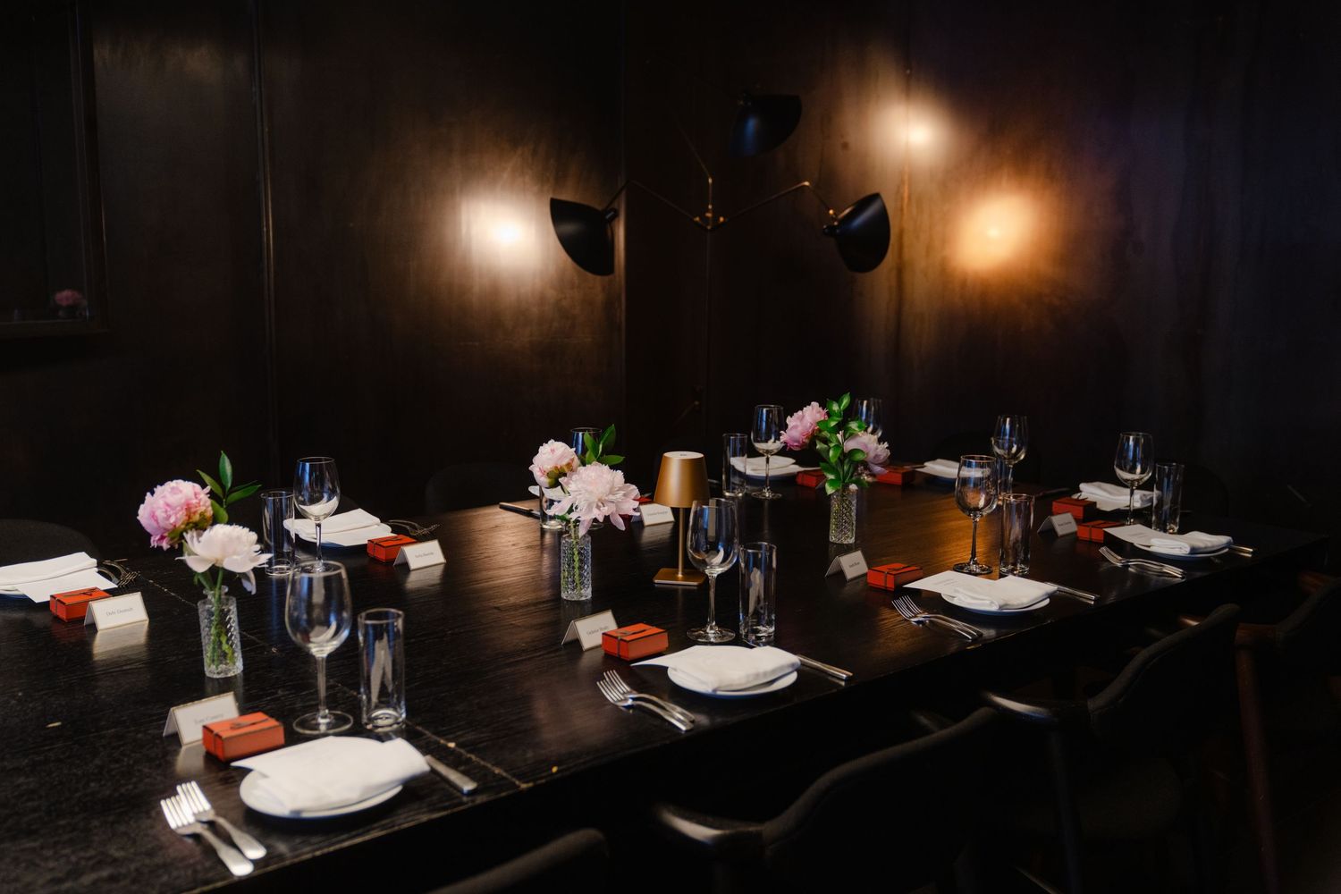 A dimly lit restaurant table setting with elegant place settings and ambient lighting creates an intimate dining atmosphere.