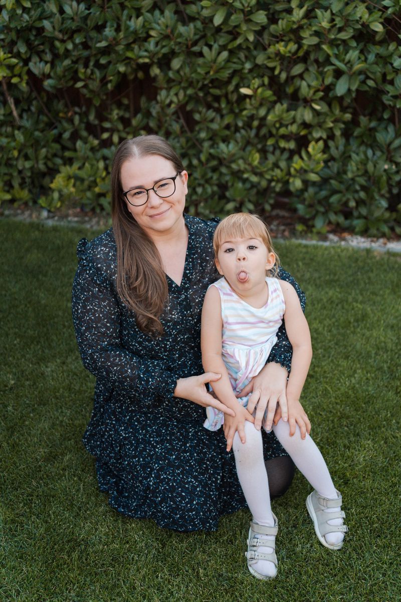 Casual outdoor family photos taken on grass with lush greenery backdrop in the family home in Rouse hill