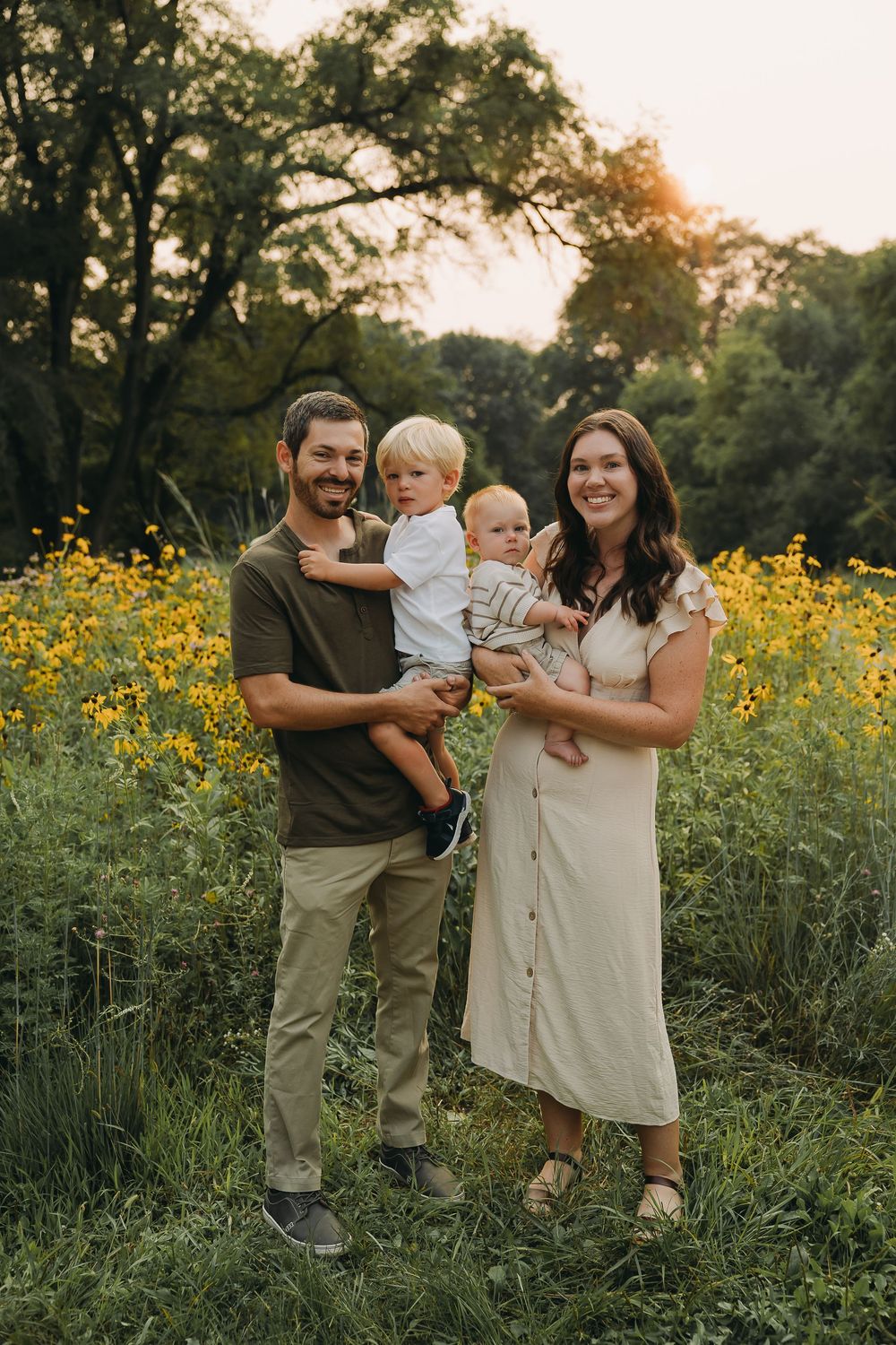 Family enjoying quality time together in a blooming meadow at sunset.