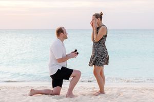 A romantic beach proposal sequence captured during golden hour.