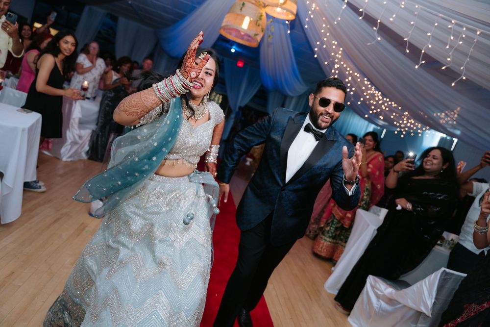 Wedding couple dancing joyfully under twinkling lights at their reception celebration.