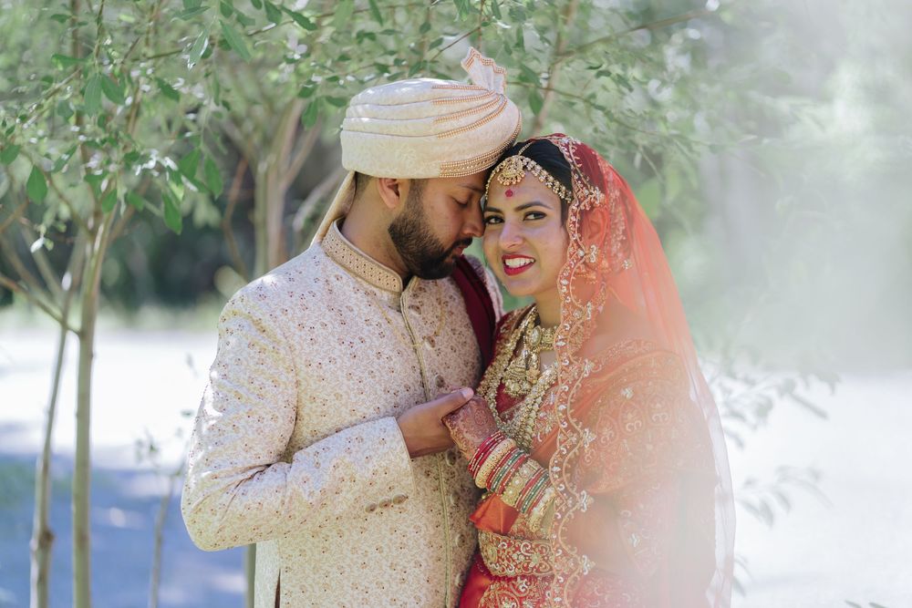 Romantic outdoor wedding photography session with couple in traditional Indian wedding attire.
