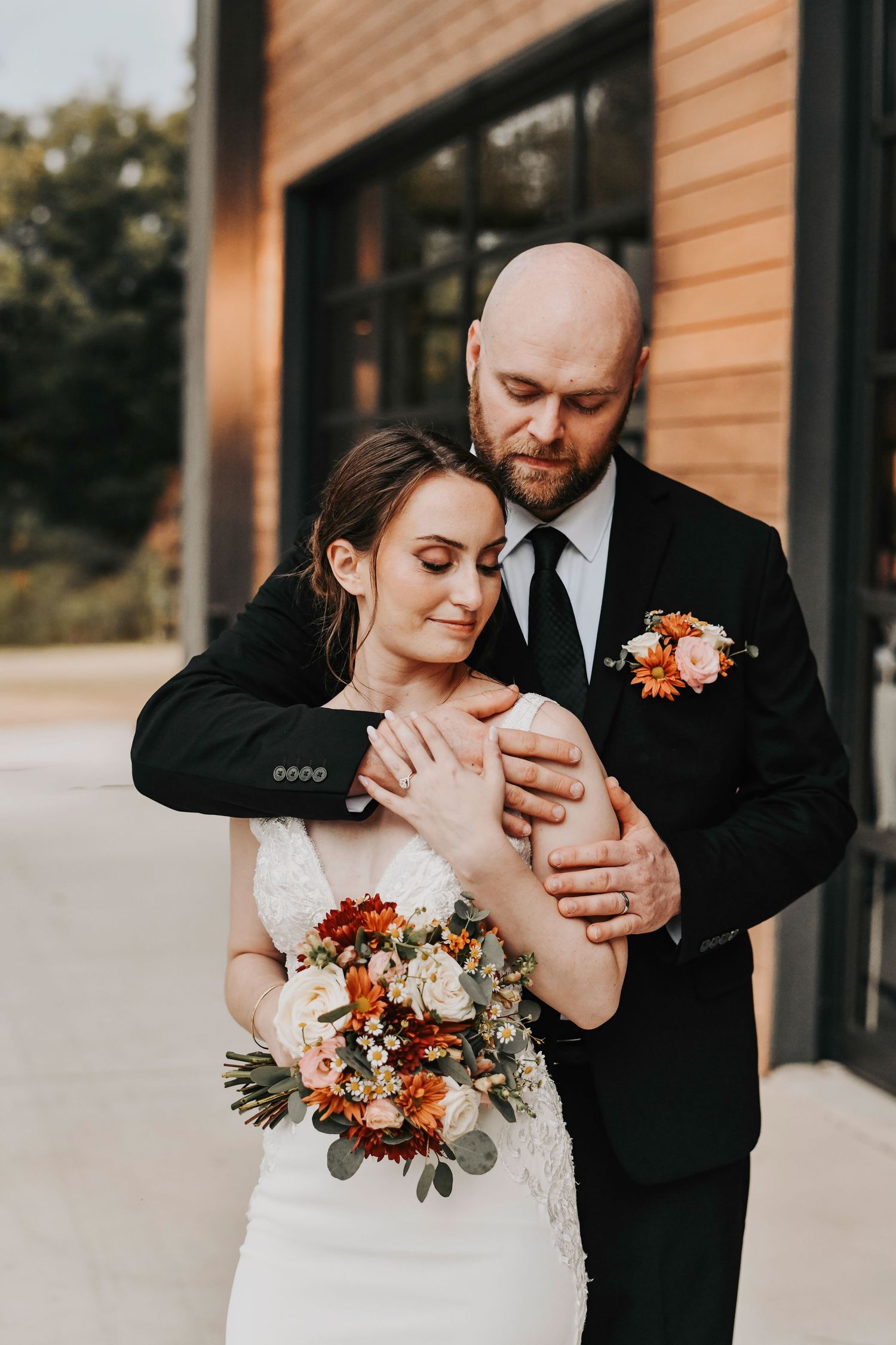a groom holds his bride in front of their wedding venue the rivers edge at tin top