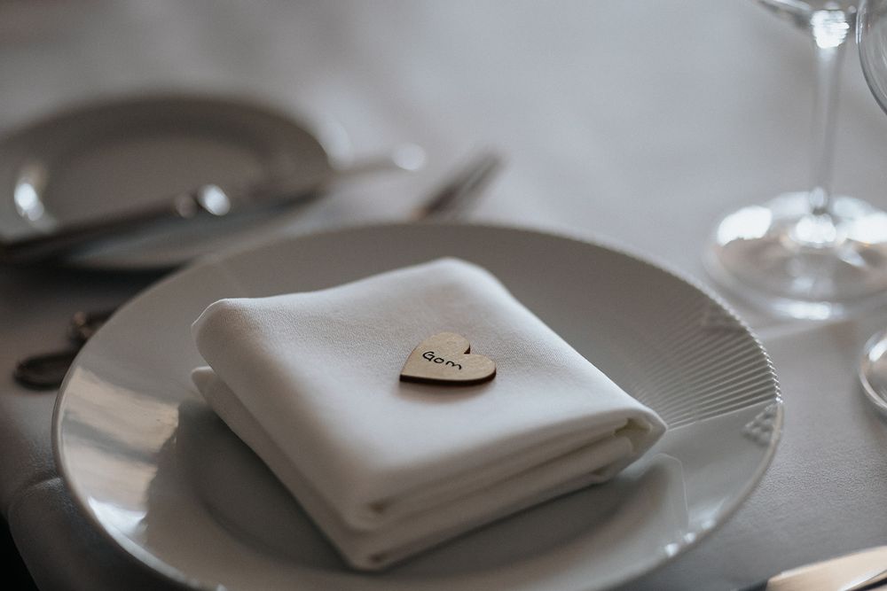 White cloth napkins elegantly folded and arranged on minimalist place settings at a formal dining table.