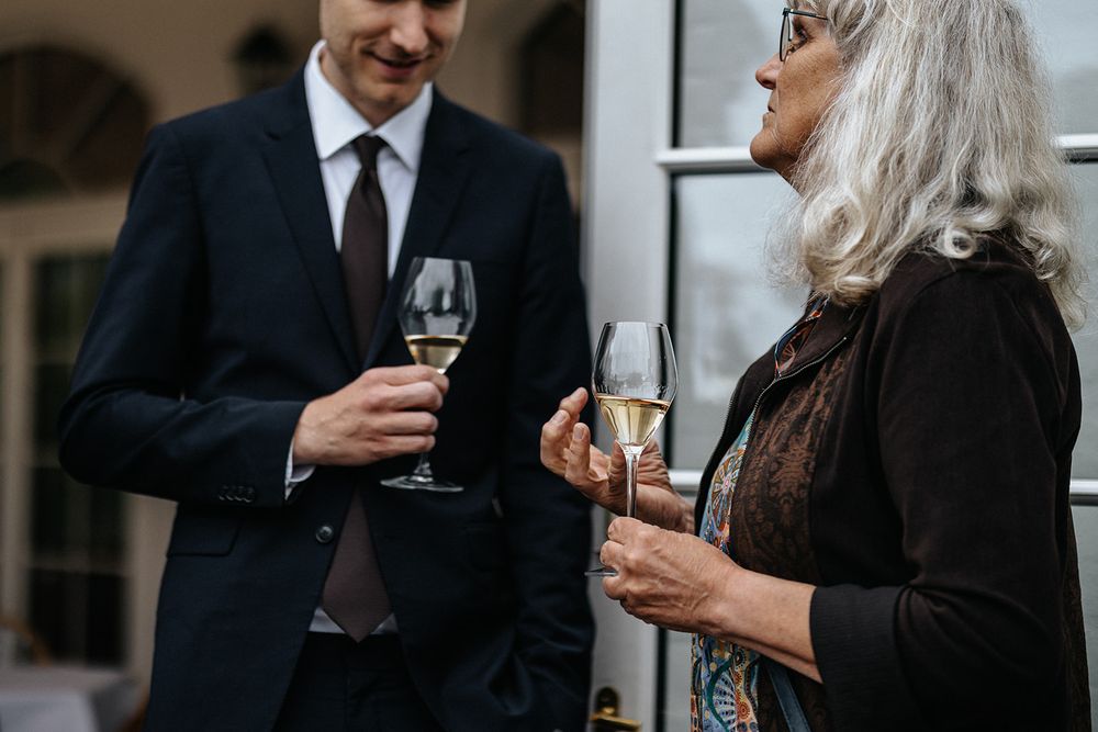 People in formal attire holding wine glasses and socializing at an elegant event.