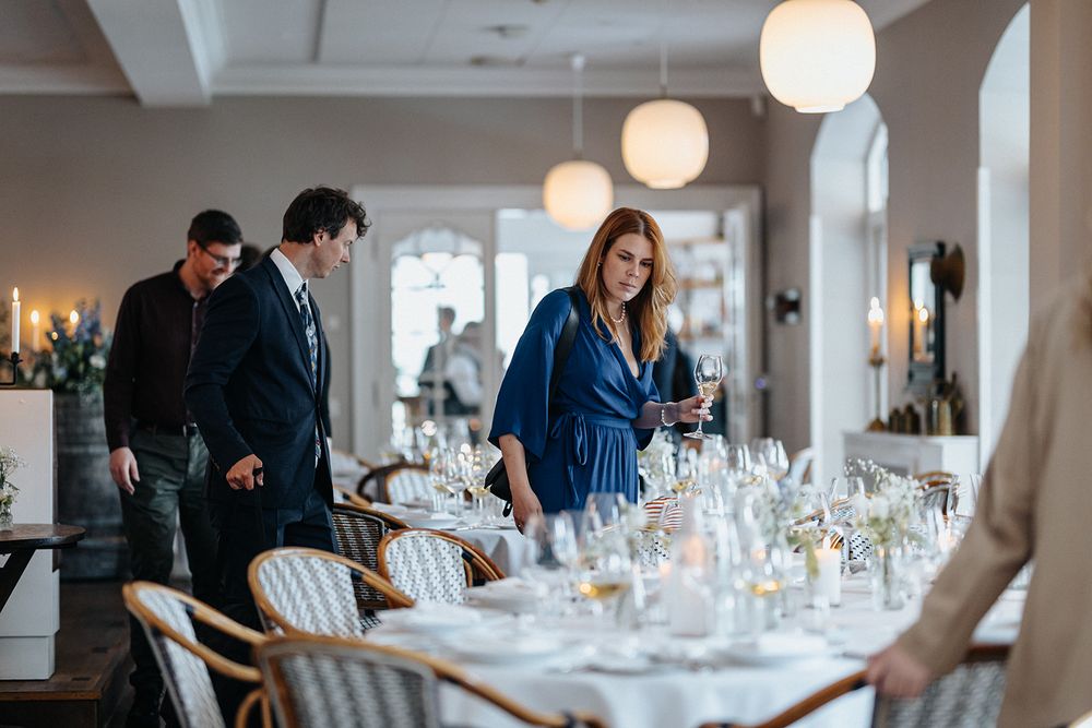 A modern wedding reception venue with white tablecloths and glowing pendant lights creating an elegant atmosphere.