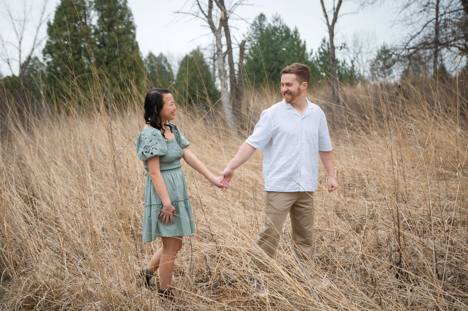 A couple sits together on stone steps wearing casual clothing in a romantic outdoor photoshoot sequence.