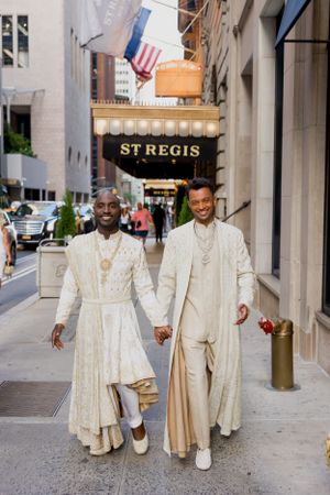 Wedding party walking down a city street in coordinated cream colored formal attire.