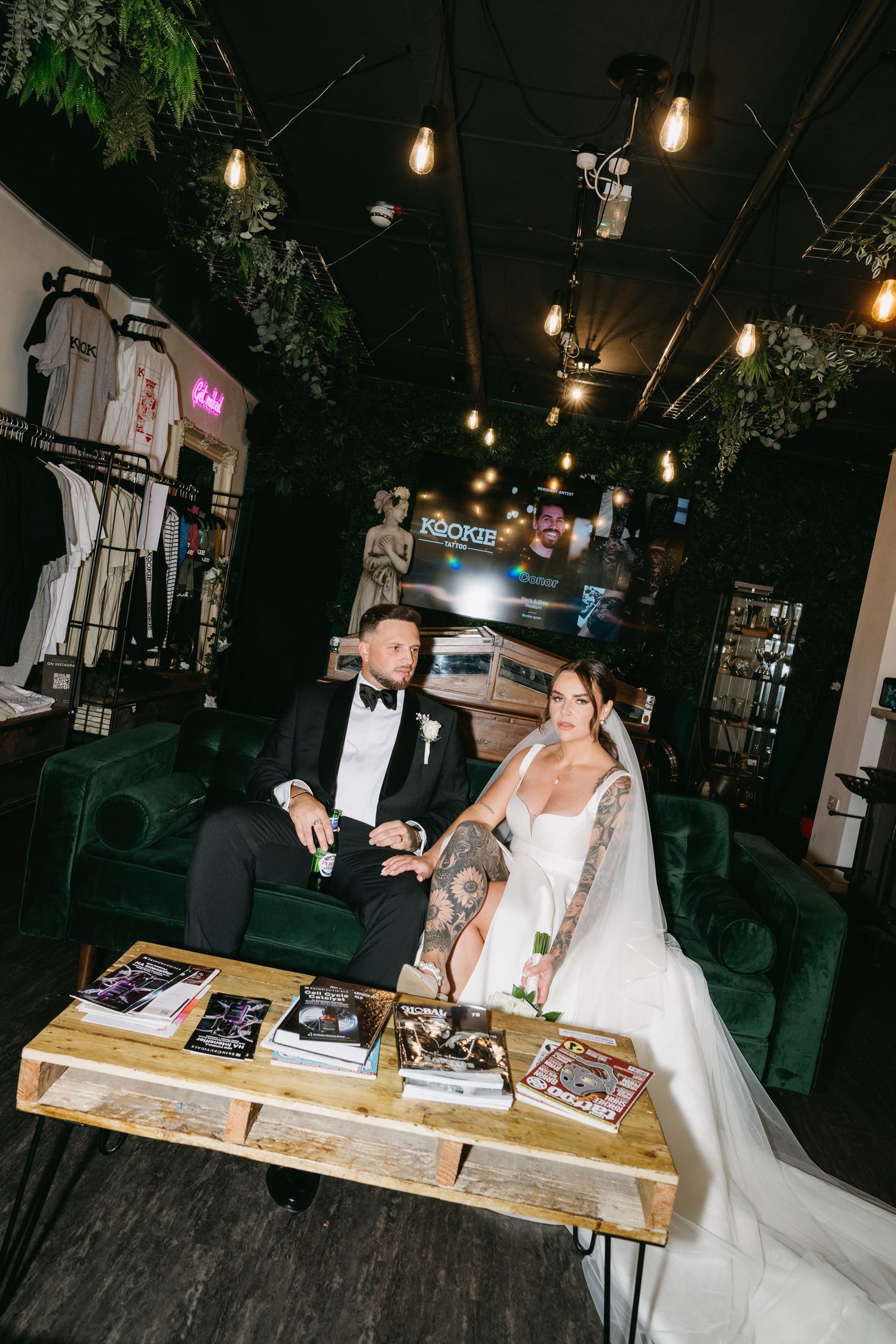 Couple in formal wedding attire enjoys a fun moment at a DJ booth during their reception celebration.