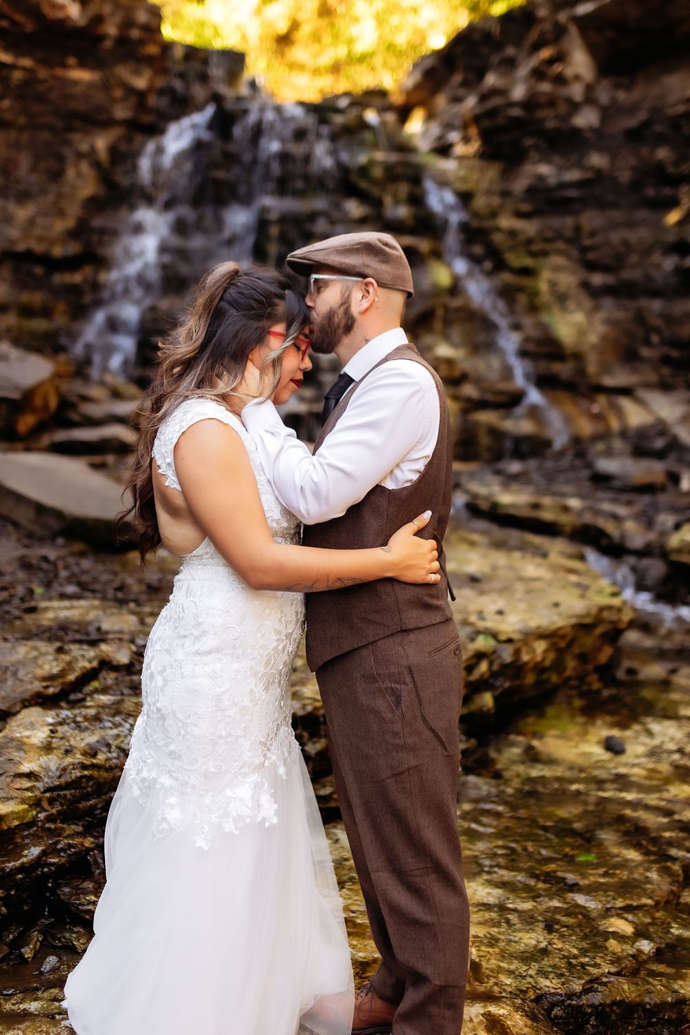 A romantic wedding photo sequence showing a couple embracing by a cascading waterfall in a natural setting.