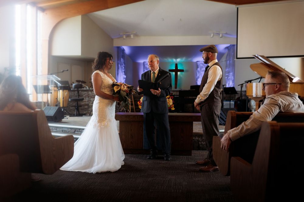 Wedding party dances together in a church reception hall during an evening celebration.