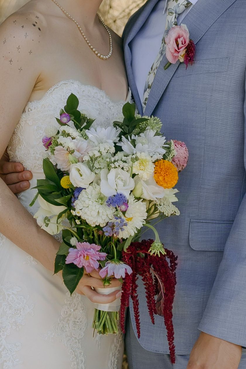 Bridal bouquet with white and colorful flowers and groom's boutonniere. Boise wedding florals. Milestones wedding planning, Boise wedding pl