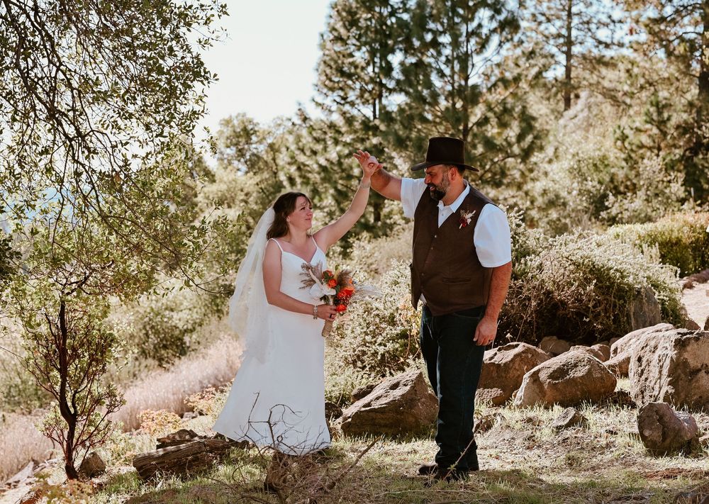 A romantic outdoor wedding photoshoot with couples in formal attire among sunlit trees and natural scenery.