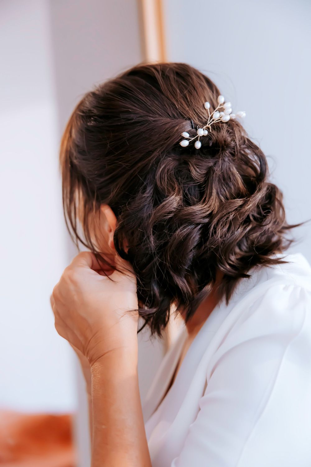 A series of photos showing delicate silver floral hair pins being styled into dark brown short hair.