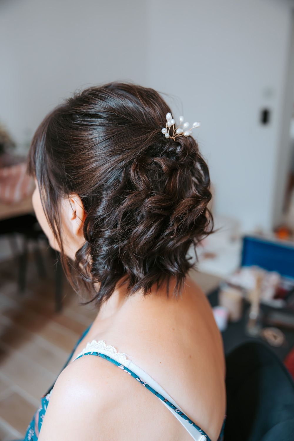 Close-up views of an elegant updo hairstyle with braided details and delicate floral hair accessories.