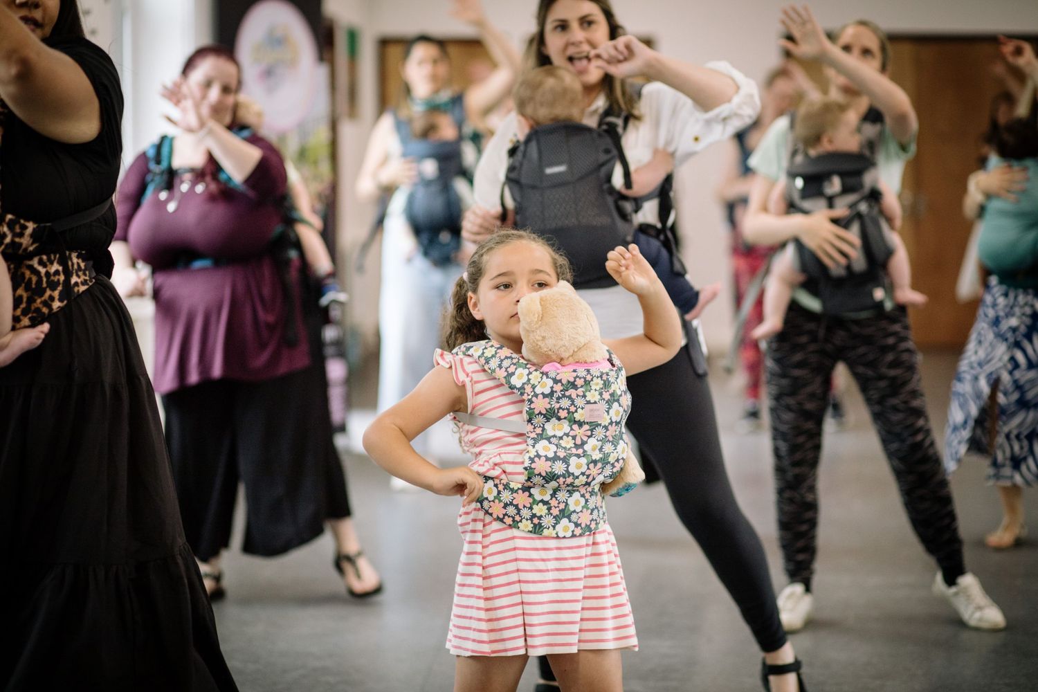 A dance class underway showing dancers following along to choreography in a bright studio space.