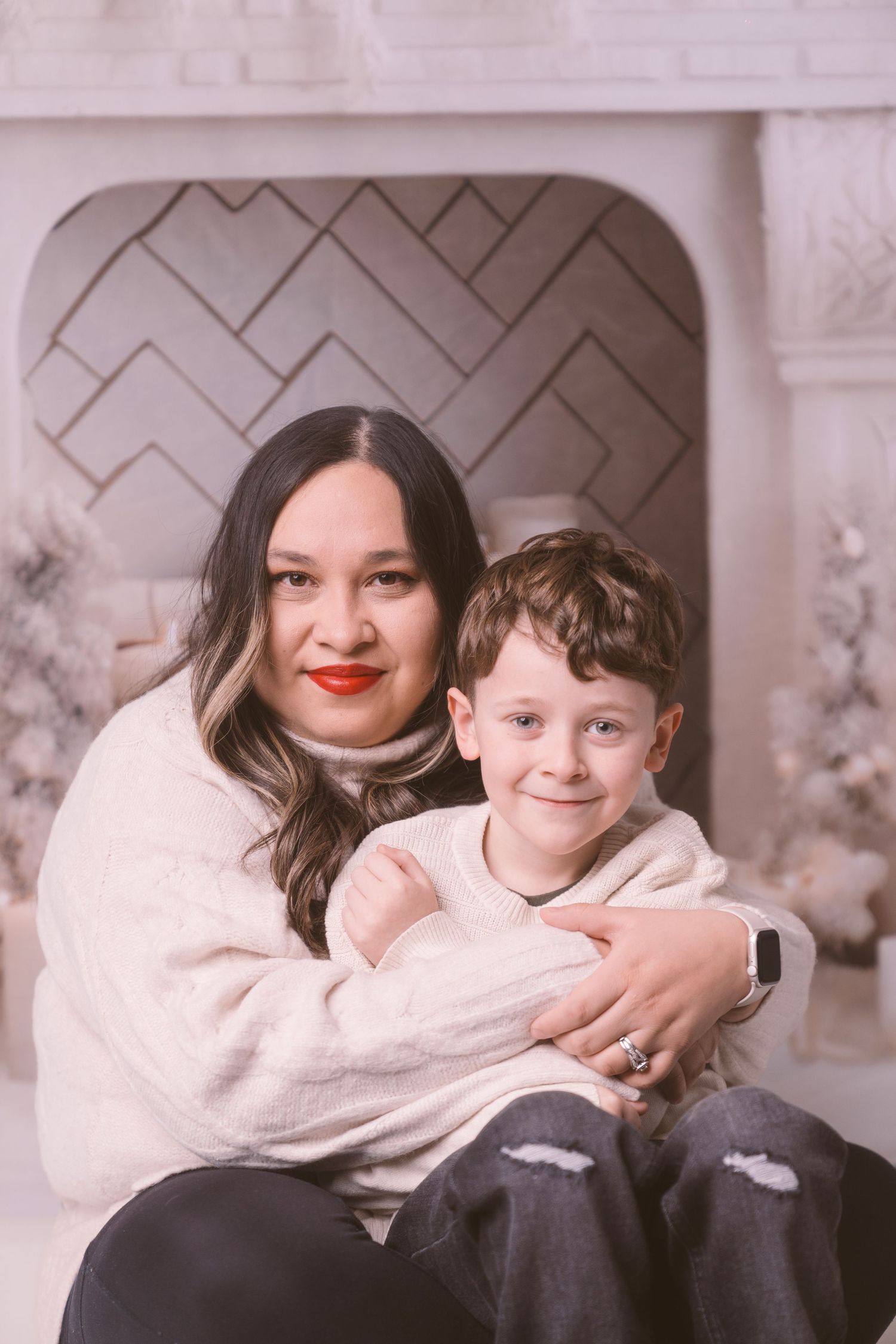 Heartwarming holiday portrait against white and silver Christmas backdrop.